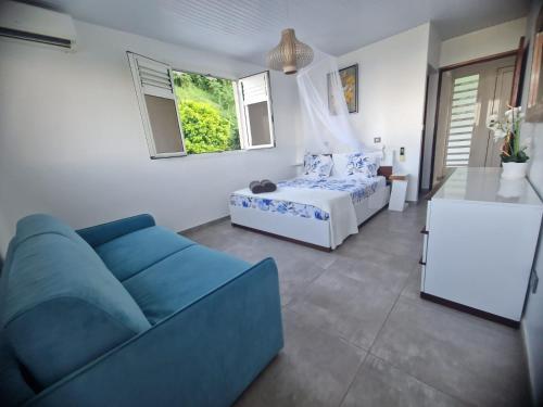 een woonkamer met een bank en een bed bij Villa Lidoam vue mer imprenable in Le Vauclin