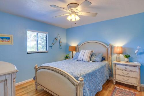 ein blaues Schlafzimmer mit einem Bett und einem Deckenventilator in der Unterkunft Waterfront Cedar Key Duplex Home with Private Dock! in Cedar Key