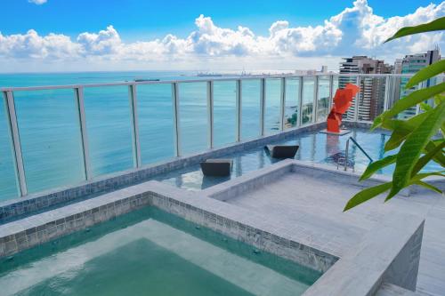 a swimming pool on the roof of a building overlooking the ocean at Seara Praia Hotel in Fortaleza