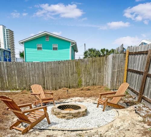 dos sillas y una hoguera en un patio trasero en Fenced House Beach Walk Sleeps 16 near St Andrew Park - Schooners, en Panama City Beach