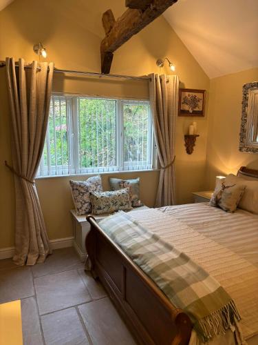 a bedroom with a large bed and a window at Mulberry House Farm Mulberry Lodge in Chippenham