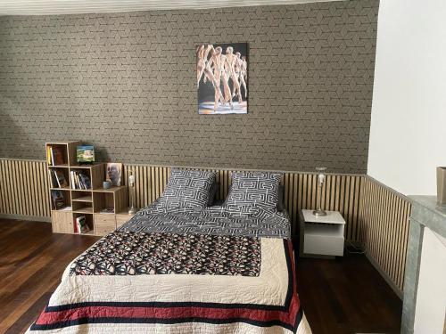 - une chambre avec un lit et un mur avec une photo dans l'établissement Appartement centre St-Mihiel, à Saint-Mihiel