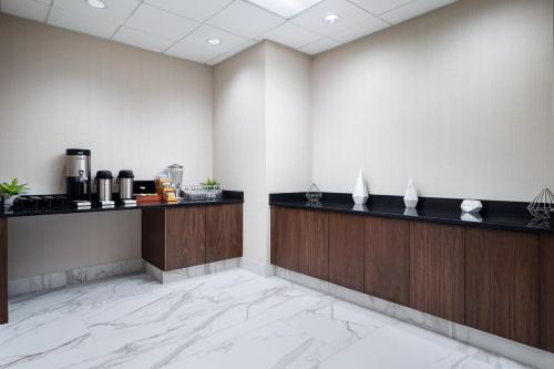 a lobby of a hotel with a counter and a coffee maker at Embassy Suites Huntsville in Huntsville
