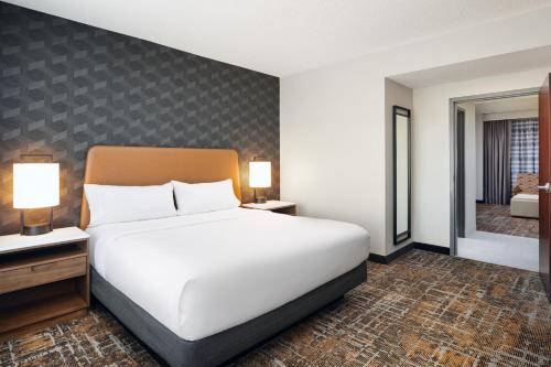 a bedroom with a large white bed and two lamps at Embassy Suites Huntsville in Huntsville