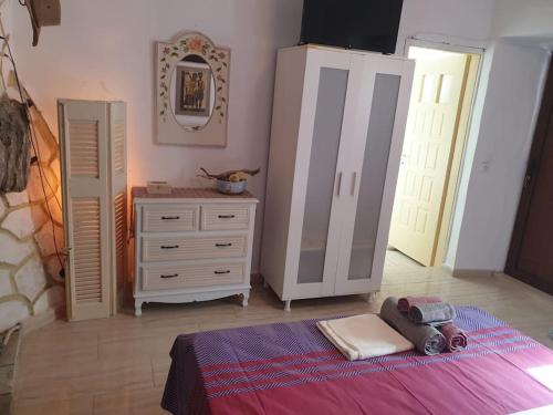 a bedroom with a bed and a dresser with a toy truck on it at To Palio Kamini in Velanídhia