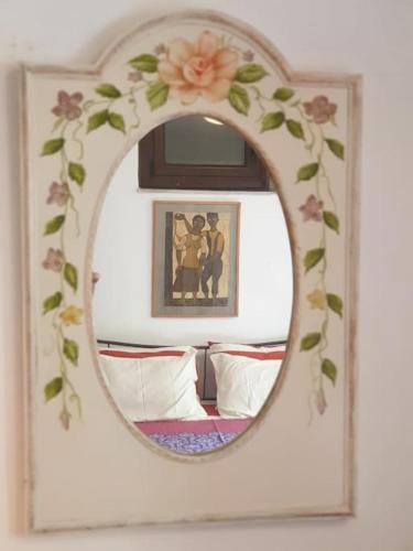 a mirror with a floral frame in a bedroom at To Palio Kamini in Velanídhia