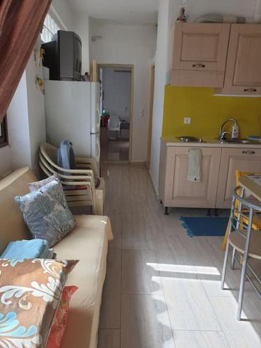 a living room with a couch and a kitchen at To Palio Kamini in Velanídhia