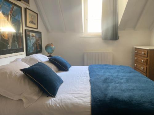 una camera da letto con un letto con cuscini blu e bianchi di Les loges du théâtre Monsigny a Boulogne-sur-Mer