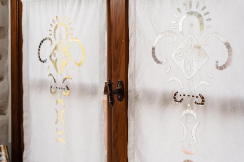 a pair of doors with white curtains on them at Feel Filoti in Philotium