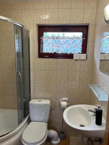 ein Bad mit einem WC, einem Waschbecken und einem Fenster in der Unterkunft Roby 45 in Mrzeżyno