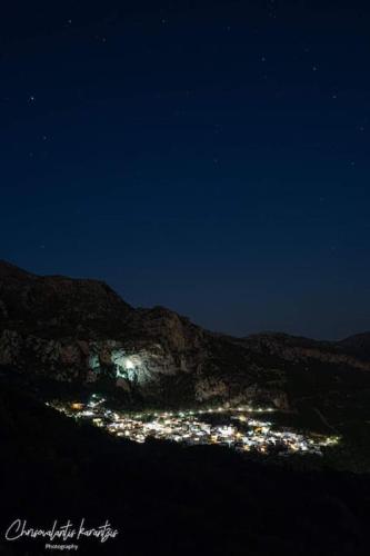 a night view of a city on a mountain at To Palio Kamini in Velanídhia