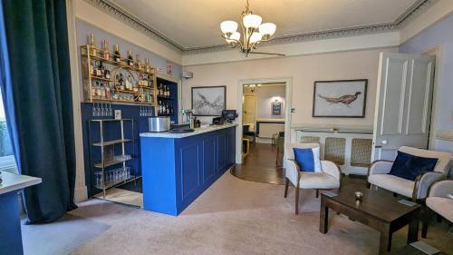 een woonkamer met een blauw eiland in een kamer bij The Abbotsford in Callander