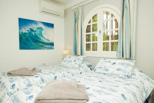a bedroom with two beds and a painting on the wall at Casa Federico in Puerto del Carmen