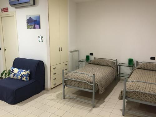 a room with two beds and a blue chair at Elicrim in Santo Stefano di Magra
