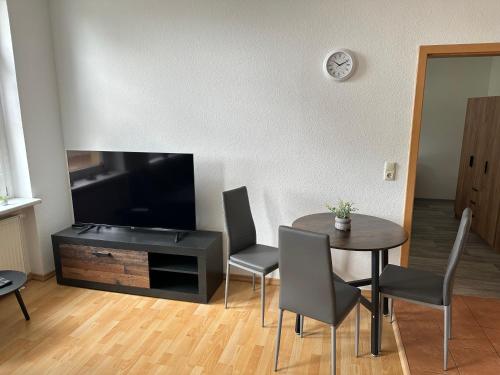 a living room with a table and a flat screen tv at Innenstadtoase im Herzen Torgelows in Torgelow