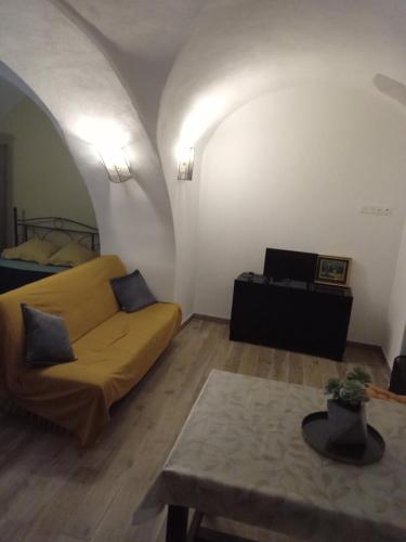 un salon avec un canapé jaune et une table dans l'établissement Studio en Haute-Corse, à Muro