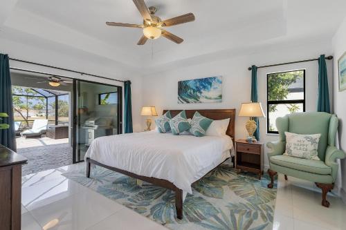 een slaapkamer met een bed, een ventilator en een stoel bij Serene Canal Views, Paddle Board, Bicycles, Heated Pool and Spa - Villa The Great Escape in Cape Coral