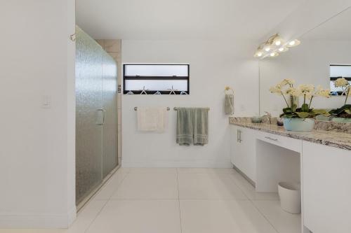 een witte badkamer met douche en wastafel bij Serene Canal Views, Paddle Board, Bicycles, Heated Pool and Spa - Villa The Great Escape in Cape Coral