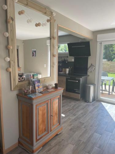 a living room with a mirror and a kitchen at GITE DES MARAIS in Saint-Étienne-sur-Suippe