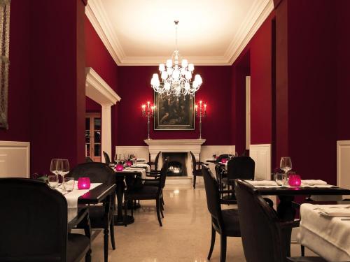 a dining room with tables and chairs and a chandelier at Il Palazzetto in Rome