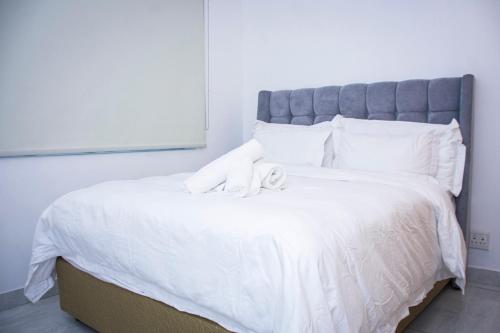 een wit bed met twee knuffels erop bij Zeno stay - No Loadshedding in Kaapstad