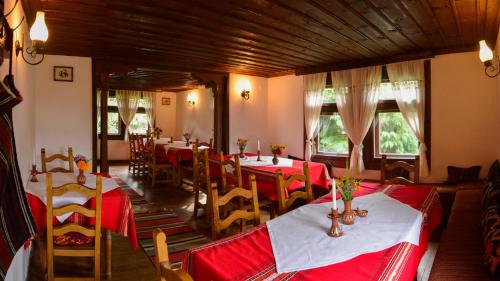 un ristorante con tavoli e sedie con tovaglia rossa di Strannopriemnitsa Guest House a Bozhentsi
