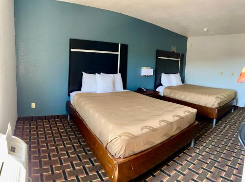 2 camas en una habitación de hotel con paredes azules en Americas Best Value Inn and Suites Albemarle, en Albemarle
