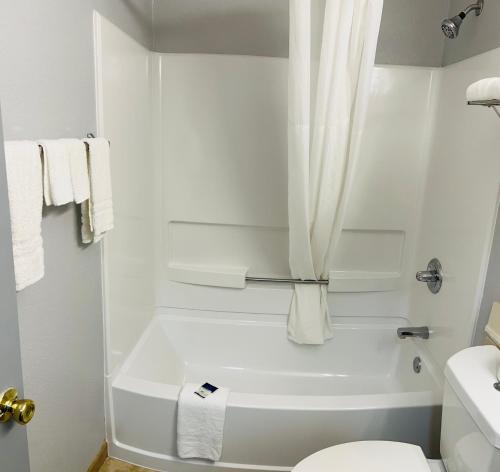 baño blanco con bañera blanca y aseo en Americas Best Value Inn and Suites Albemarle, en Albemarle