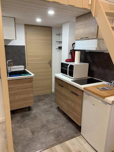 une cuisine avec un évier et un micro-ondes dans l'établissement Studio cosy 2 pers en plein centre avec balcon, à Le Touquet-Paris-Plage