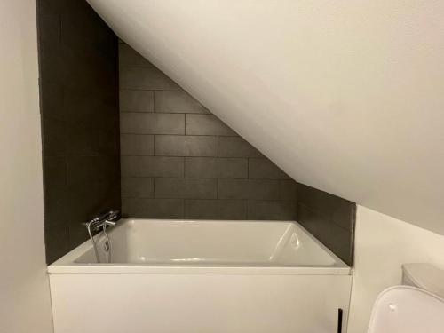 La salle de bains est pourvue d'une baignoire blanche. dans l'établissement Jolie maison avec jacuzzi 10 pers, parc Astérix, à Cinqueux