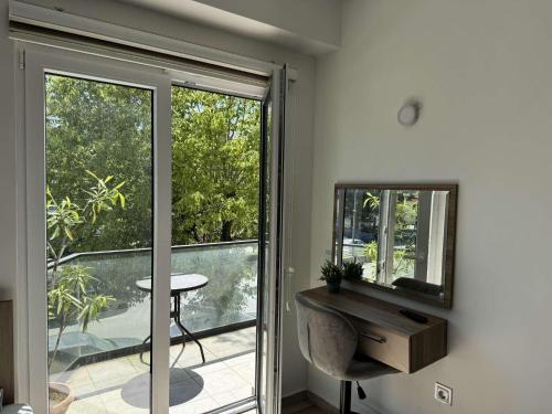 オフリドにあるParadiso Apartmentsの窓、テーブル、鏡が備わるお部屋