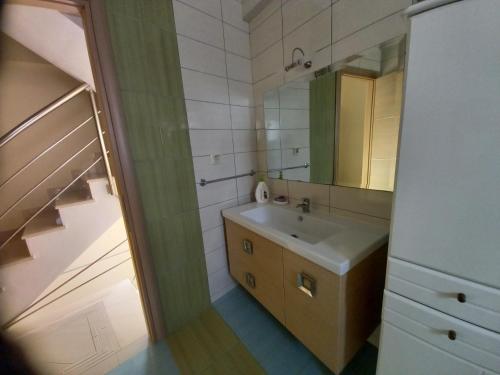 a bathroom with a sink and a mirror at Mountain & Sea View VILA in Áyios Andréas