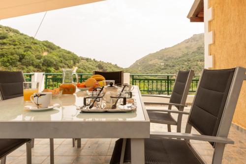 een tafel met eten en drinken op een balkon bij Villa Araxovoli in Palaiochóra