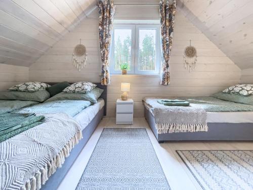 a attic bedroom with two beds and a window at LaSpokój in Siemiatycze