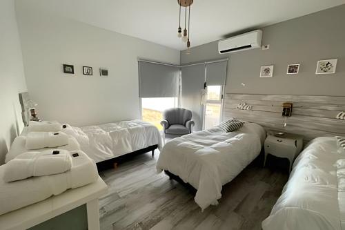 a hospital room with two beds and a chair at El Galpon de Solana in Puerto Madryn
