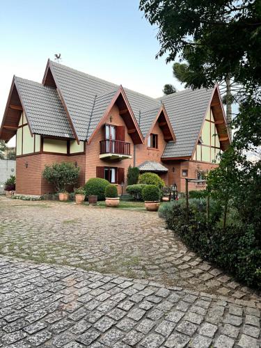 a large brick house with a roof at Vila husky pousada in Campos do Jordão