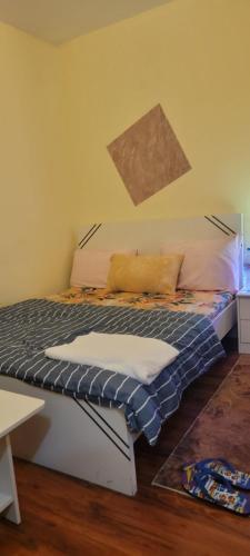 a bedroom with a bed with a painting on the wall at Home Away Apartment in Abu Dhabi