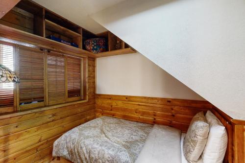 a bedroom with a bed in a room with wooden walls at Kings Run Relaxation in Kings Beach