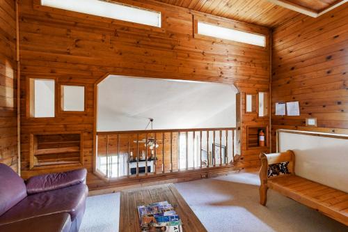 ein Wohnzimmer mit Holzwänden, einem Sofa und einem Tisch in der Unterkunft Kings Run Relaxation in Kings Beach