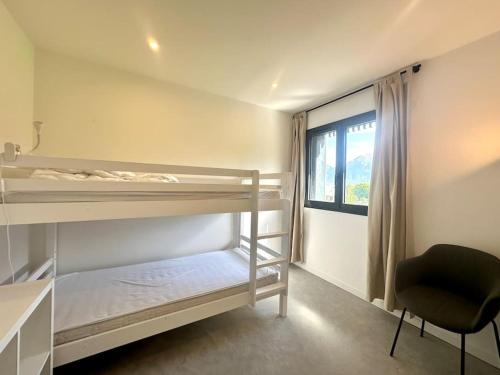 - une chambre avec des lits superposés, un bureau et une chaise dans l'établissement Maison moderne avec vue imprenable - 5min du lac, à Crots