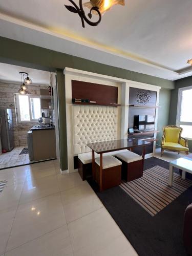 a living room with a table and a kitchen at Downtown Sea View Suites in Alexandria