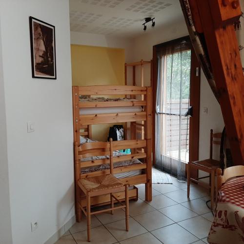 Cette chambre dispose de lits superposés en bois et d'une chaise. dans l'établissement Charmant appartement avec espace détente, à Saint-Étienne-en-Dévoluy