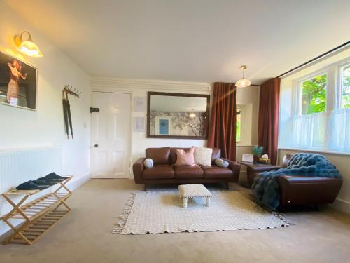 a living room with a couch and a chair at Sandford Mount in the Costwolds in Charlbury