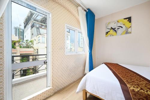 een slaapkamer met een bed en een raam bij Ha Vy Hotel in Ho Chi Minh-stad