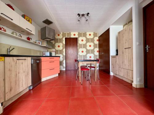 a kitchen with a red tile floor and a table at Royan Villa 1970 in Royan