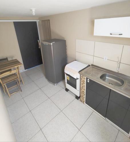 uma pequena cozinha com um lavatório e um frigorífico em Abaré Slim Suítes em São Miguel dos Milagres