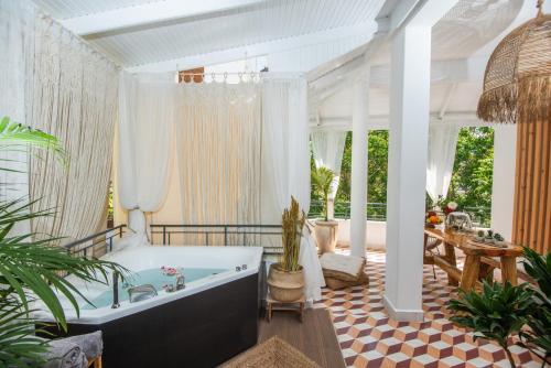 - une salle de bains avec baignoire dans une chambre ornée de plantes dans l'établissement Menemar Suite & Apt, By IdealStay Experience, à Agios Nikolaos