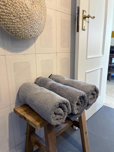 a bunch of towels sitting on a wooden stool at Villa O Altinho Carrapateira in Carrapateira