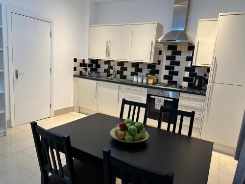 Una cocina con una mesa con un bol de fruta encima. en Westferry, en Londres
