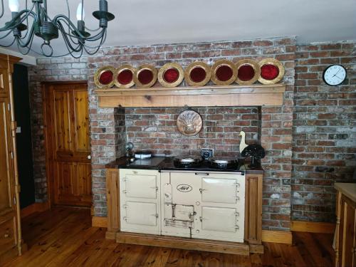 a kitchen with a brick wall with bowls on the wall at Bushmount Lodge in Clonakilty